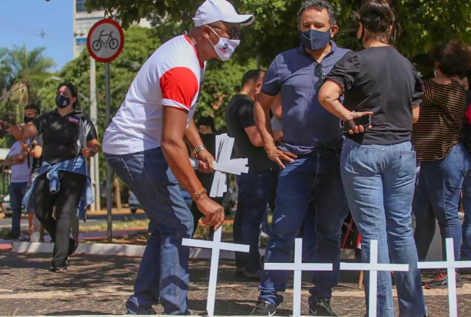 Manifestante coloca cruzes no Centro de Campo Grande, em protesto contra mortes por covid no País. (Foto: Marcos Maluf)