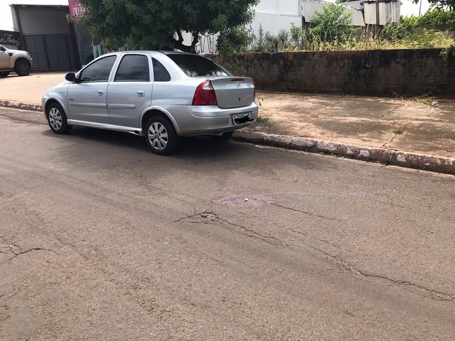 Sangue dos dois baleados ficou no asfalto, perto do carro da mulher — Foto: Graciela Andrade/ TV Morena