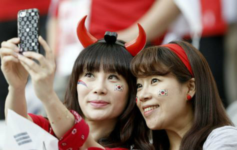 Torcedoras da Coreia do Sul fazem selfie durante partida entre Bélgica e o país asiático.FOTO: EFE